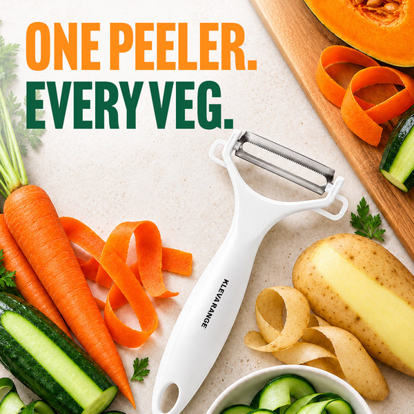 A Kleva Range Precision Peeler With Ultra Sharp Double-Sided Stainless Steel Blades rests on the countertop beside carrots, potatoes, cucumber, and squash. Vibrant ribbons and slices of peeled vegetables surround the sleek white peeler with its ultra-sharp stainless steel blades. Text reads: ONE PEELER. EVERY VEG.