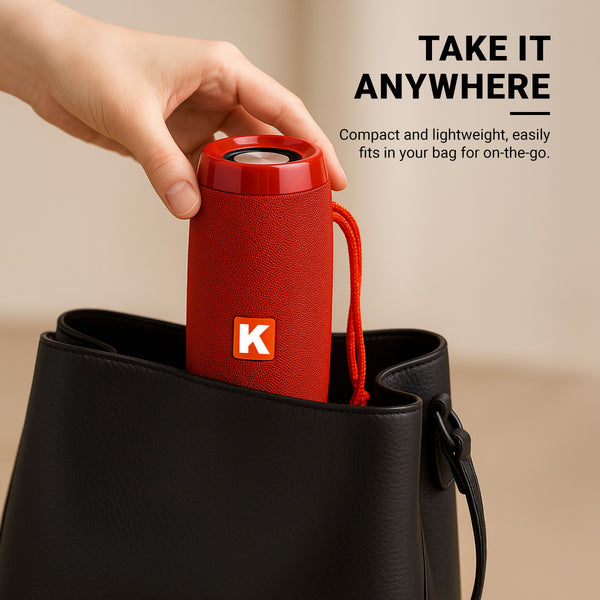 A hand places the compact red Kleva® Glow Beats Speaker by Kleva Range into a black handbag. Text reads, Take it anywhere. Enjoy crystal-clear sound in a portable speaker that fits easily in your bag for on-the-go moments.