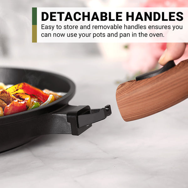A person removes a wooden handle from a black pan on a marble counter. Text: Kleva Range Diamond Earth® StackSmart 6pc Cookware Set features detachable handles for easy storage and oven use. Buy one GET ONE FREE!.