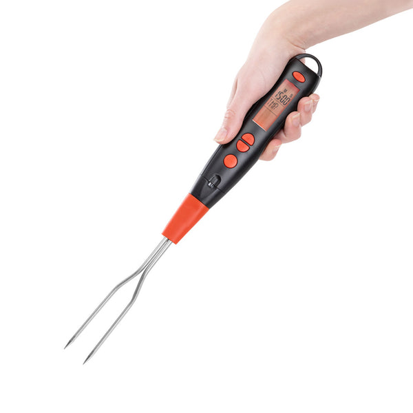 A hand holds the KLEVA Flavour Fork™ Digital BBQ Fork by Kleva Range, featuring a black and red handle, metal prongs, LCD display, and control buttons for accurate cooking temperature readings.