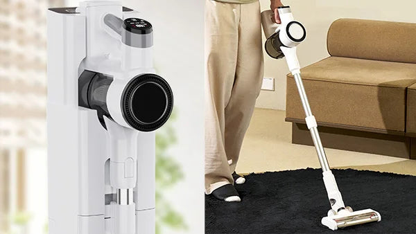 White KRAPOF Self-Emptying Stick Vacuum stored in dock and being used on a black rug in a living room.