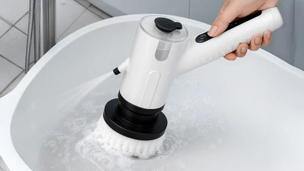 KRAPOF Tough Scrub Excel Pro electric cleaning brush with integrated water spray cleaning a white bathtub.