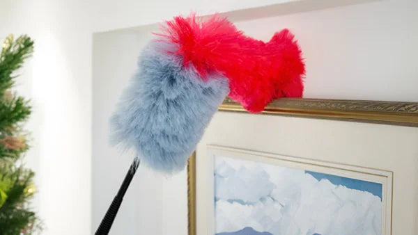 Miracle Magnetic Duster with flexible head removing dust from the top of a hanging picture frame.