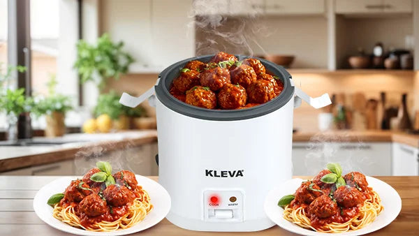 White Kleva One Button Cooker filled with steaming meatballs in tomato sauce, flanked by two plated servings of spaghetti and meatballs.
