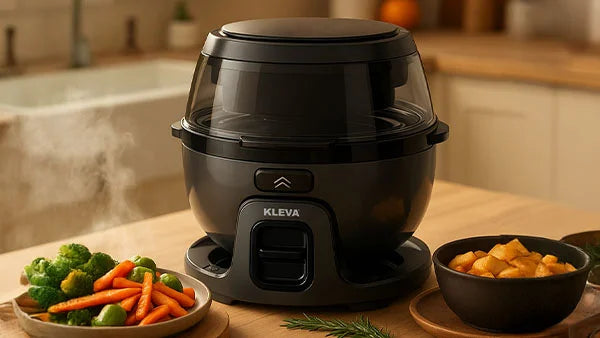Kleva Spin Crisp Air Fryer on a kitchen countertop featuring a transparent lid and steaming healthy vegetables and roasted potatoes.
