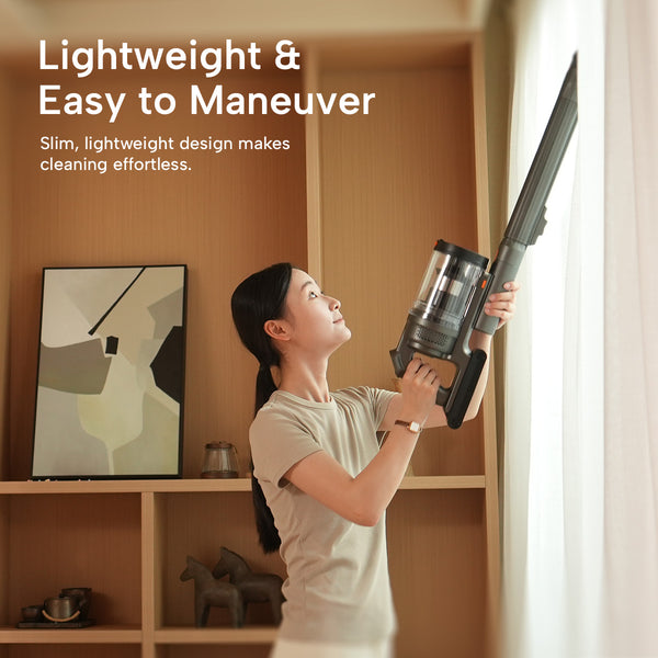 Woman using a Auto Clean Power Q3 vacuum to clean high spots near a window curtain