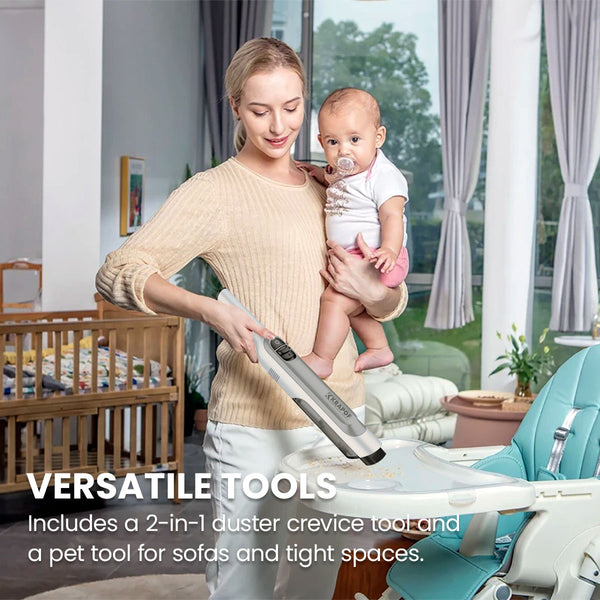 A woman holds a baby while using the KRAPOF® Portable Mini Plus Handy Cordless Car Vacuum Cleaner by Kleva Range to clean a high chair in a bright room. Text highlights the vacuum’s versatile tools.