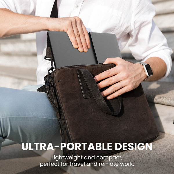 A person packs the Kleva Range Kleva Portable 15.6" Screen Extender and a slim laptop into a black leather briefcase outdoors. Overlay text: ULTRA-PORTABLE DESIGN—Lightweight, compact, ideal for travel and remote work.