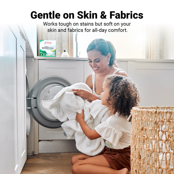 A woman and young girl kneel by a front-loading washer with white towels and a wicker laundry basket. Kleva Range Stain Lifting Laundry Detergent Sheets Fresh Linen 40 Sheets are shown, noting they're gentle on skin, fabrics, and the environment.