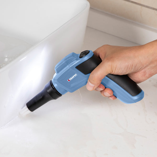 A hand holds the KRAPOF® Electric Lumi Scrub Pocket Cleaner by Kleva Range, featuring five replaceable cleaning heads—ideal for easily removing tough stains.