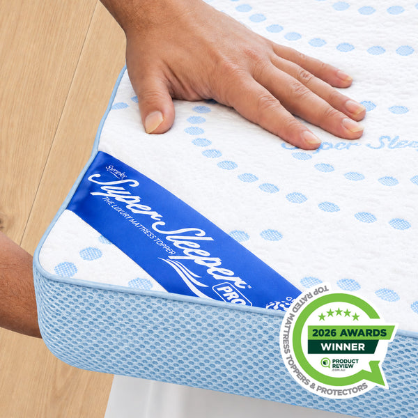 A hand presses down on a white and blue Straight 2 Sleep® Mattress Topper with Cooling Technology by Super Sleeper Pro, highlighting its enhanced sleep comfort. A badge in the corner reads 2026 Awards Winner, Product Review, Mattress, Topper & Protectors. Plus: Includes 2 BONUS pillows.