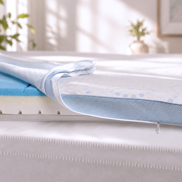 A close-up of the Super Sleeper Pro Straight 2 Sleep® Mattress Topper with Cooling Technology + 2 BONUS Pillows shows the zippered cover partially open, revealing layers of blue and white foam engineered for exceptional sleep comfort. Sunlight pours in from a window, illuminating the advanced cooling technology within, while a potted plant adds a touch of greenery in the background.