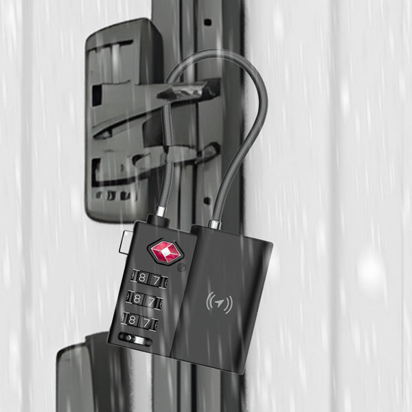 The Kleva Range TSA LockSmart Travel Tag Bluetooth Tracker for Apple Find My is attached to a metal latch outdoors in the rain. The black lock features a wire shackle, four dials set to 1-8-7-1, and a small red logo.