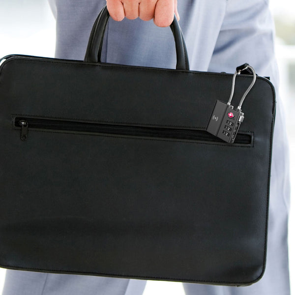 A person in a light gray suit holds the Kleva Range TSA LockSmart Travel Tag Bluetooth Tracker for Apple Find My, featuring a front zipper pocket with TSA-approved lock and including a free Travel Tips ebook.