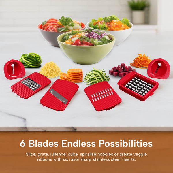 Three salads in bowls are in the background. In the foreground, the Kleva® Spin, Slice & Dice by Kleva Range displays six types of sliced vegetables and four red slicer attachments on a wooden surface. Blade info appears below.
