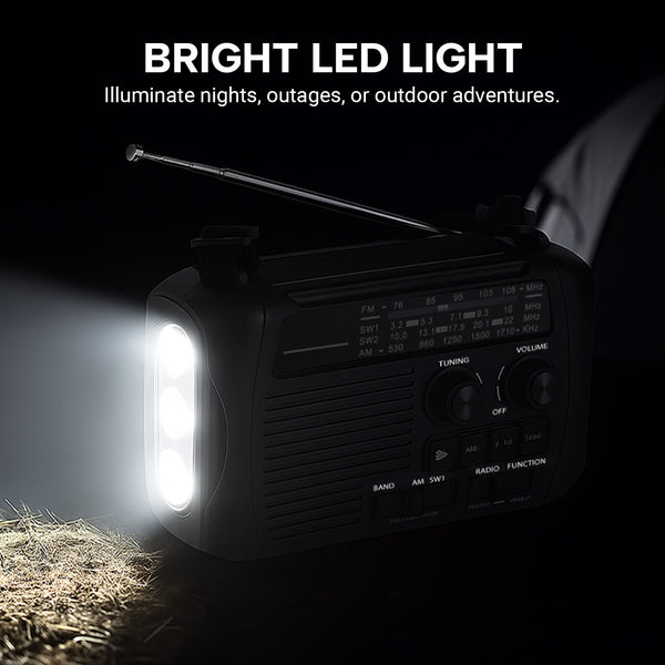 The KLEVA® All-in-1 Survival Radio by Kleva Range, featuring an extending antenna, sits on the ground as its side LED glows brightly. Above, text reads: BRIGHT LED LIGHT—perfect for nights, power outages, or outdoor adventures.