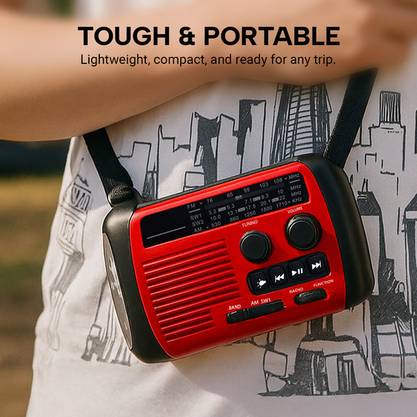 A person wears the KLEVA® All-in-1 Survival Radio from Kleva Range with a black strap around their neck. The red solar & hand-crank powered FM/AM radio features dials, buttons, and an LED light. Background shows a cityscape-themed shirt and text about its durability.
