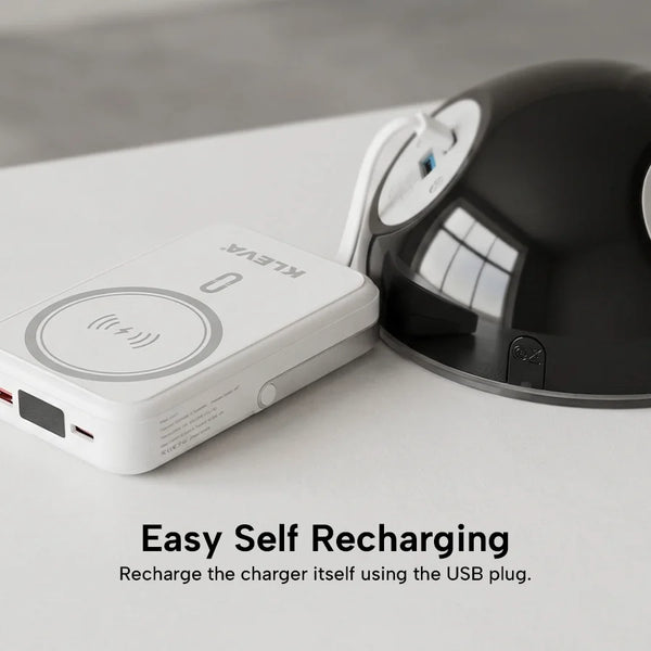 White power bank with wireless charging pad and USB plug on a gray surface.