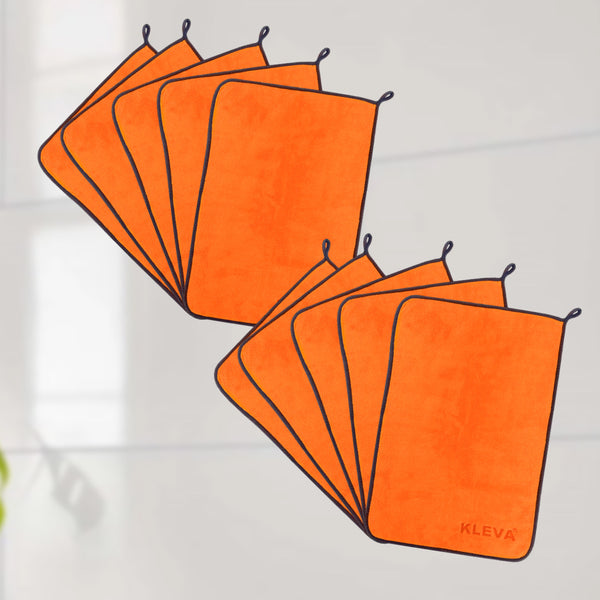 Eight orange microfibre cloths from the Kleva Range’s The World's Best Cleaning Cloth are shown in two overlapping groups. These reusable cloths have black edges, small hanging loops, and “KLEVA” marked on one in the bottom right corner.