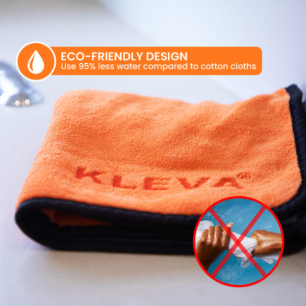 An orange microfibre cloth with a black border and "KLEVA" on it lies on a white surface. A label notes The World's Best Cleaning Cloth by Kleva Range uses 95% less water than cotton. Inset: hands with water and a red X signal eco-friendly cleaning.