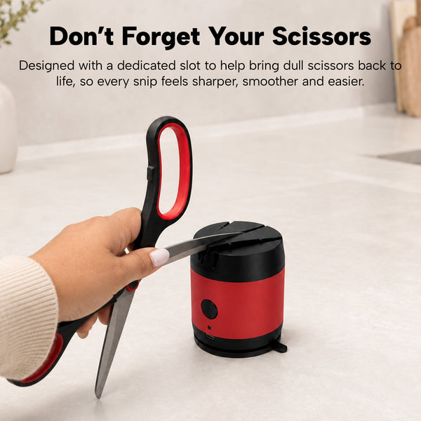 A hand sharpens scissors in the KLEVA® ElectraSharp by Kleva Range, a red and black electric knife sharpener on a kitchen counter. Text highlights its special slot for scissors to keep them sharp and easy to use.