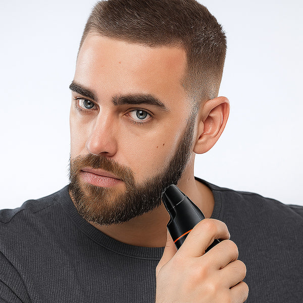 A man with a trimmed beard and short hair uses the KLEVA® 5-in-1 Professional Hair Trimmer + Men’s Body & Beard Groomer by Kleva Range. Wearing a dark gray shirt, he looks directly at the camera against a plain white background.