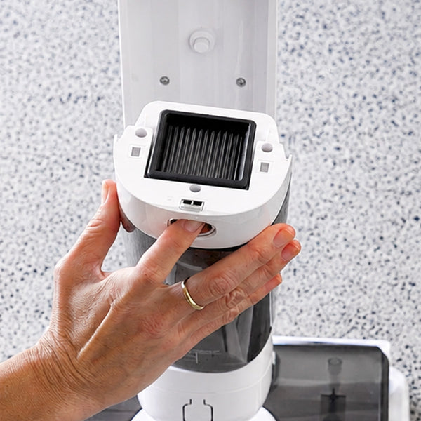 A hand is removing a rectangular black filter from the Kleva Range FX5 Floor Washer against a speckled grey surface background, demonstrating the use of the Filter Kit (2 pack).