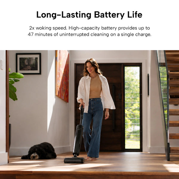 A woman cleans a wooden floor in a modern entryway with her black dog nearby, using the Kleva Range KRAPOF® FX5 HydraClean Cordless Hard Floor Washer. Enjoy up to 47 minutes of streak-free cleaning per charge with long-lasting battery life.