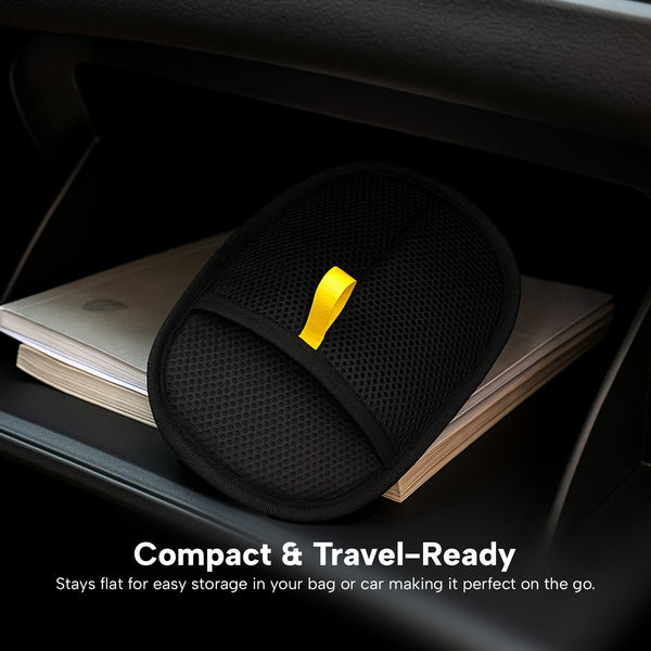 A black KLEVA® Lint Lift™ glove by Kleva Range rests on a closed laptop in a car. Text: Compact & Travel-Ready—stays flat for easy storage in your bag or car; perfect for on-the-go lint and pet hair removal. Buy 1 Get 1 Free!.