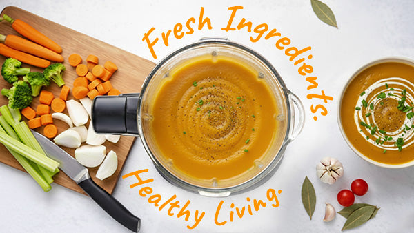 Blender filled with soup surrounded by fresh vegetables and ingredients on a white background.