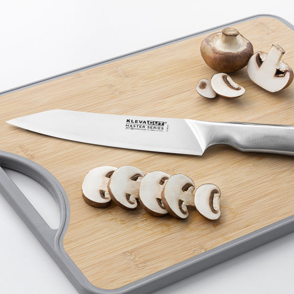 A Kleva Range KlevaCut® Master Series Professional Oriental Cooks Knife - 18cm is placed on a light wooden cutting board with gray edges, along with several sliced and whole mushrooms.