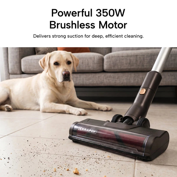 The KRAPOF® Power Vac S3 Cordless Stick Vacuum by Kleva Range sweeps crumbs from a tiled floor, with a yellow dog nearby. Powerful 350W brushless motor delivers strong suction and the lightweight design includes a FREE second battery.