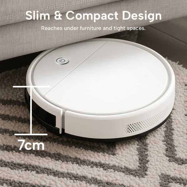 The KRAPOF® Slim Robo Vac by Kleva Range glides under a beige sofa on a light rug, showcasing its super quiet cleaning, smart navigation, and ultra-slim 7 cm design for efficient, hands-free vacuuming.
