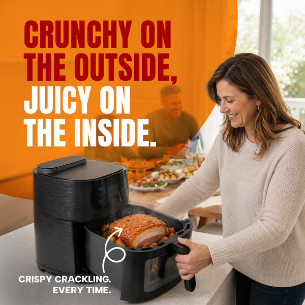 A woman places seasoned meat into a black KLEVA® SteamCrisp IQ Steam Air Fryer with AI Food Detection Camera 8L by Kleva Range in a bright kitchen. Text on the image reads: Crunchy on the outside, juicy on the inside. Crispy crackling. Every time, thanks to smart food recognition and steam-assisted air fryer technology.