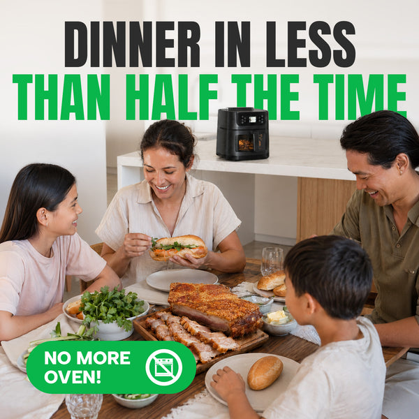 A family of four gathers at a dining table filled with an array of dishes, such as meat and bread. On the counter behind them sits the Kleva Range KLEVA® SteamCrisp IQ Steam Air Fryer with AI Food Detection Camera 8L. Text reads: DINNER IN LESS THAN HALF THE TIME and NO MORE OVEN!.