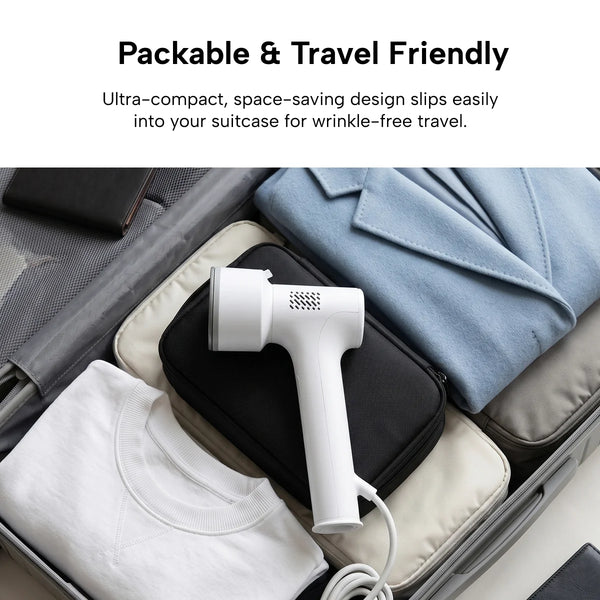 The KLEVA® AirPress handheld garment steamer by Kleva Range, shown packed in an open suitcase beside a blue blazer and white shirt, showcases its packable, travel-friendly design—no ironing board needed for wrinkle-free clothes on the go.