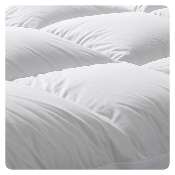 Close-up of the Super Sleeper Pro Marshmellow™ Plush Mattress Topper, showing its white quilted surface with soft, puffy sections and visible stitching. The topper looks smooth and cushiony; includes 2 free pillows.