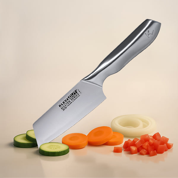 The Kleva Range KlevaCut® Master Series Professional Vegetable Knife - 14cm, with its ergonomic handle, stands upright among sliced cucumbers, carrots, onion rings, and diced red bell peppers on a light surface.
